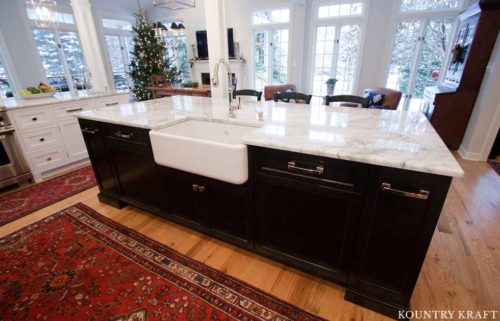 White Farmhouse Sink designed for a Kitchen Island with Black Cabinets and Marble Countertop
