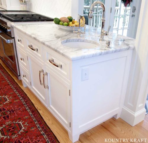 Undermount Sink with Marble Countertops Featured with White Kitchen Cabinets in this Transitional Kitchen 