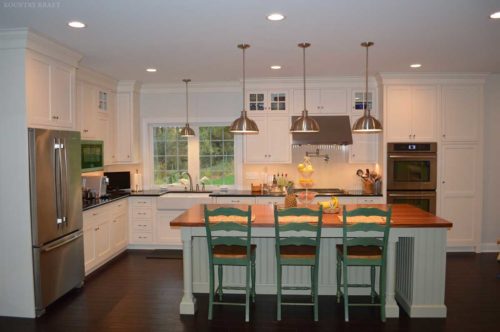 White cabinets and island with three green chairs Wyomissing, PA