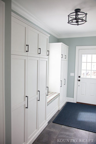 white entryway features custom closets and cabinetry