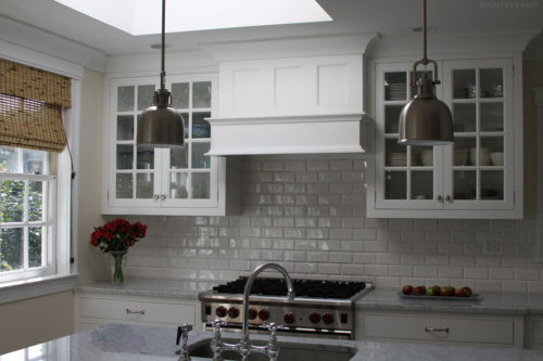 White kitchen cabinets, sink, and range