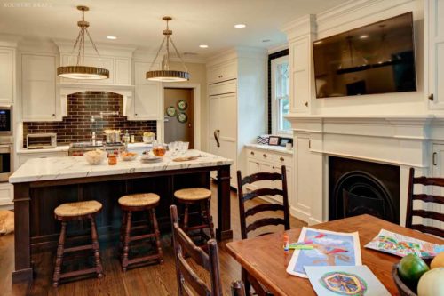 White kitchen cabinets, island, TV, and fireplace Millburn, NJ