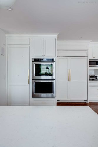 White kitchen with ovens next to a closed pantry Short Hills, NJ