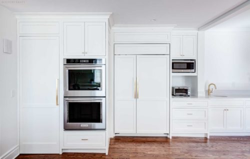 White kitchen including ovens, sink, and refrigerator cabinetry Short Hills, NJ