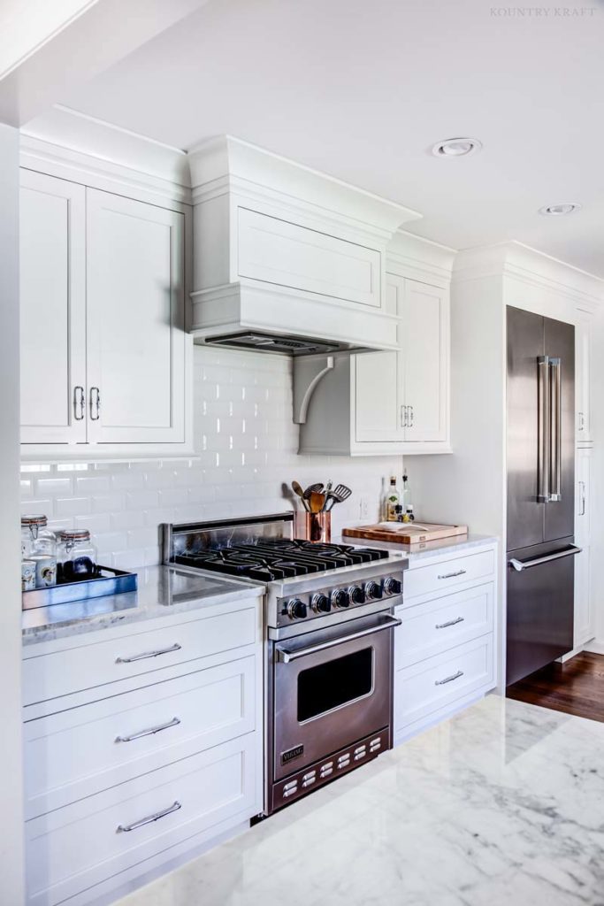 Refrigerator, range, and cabinetry in a white kitchen Upper Montclair, NJ