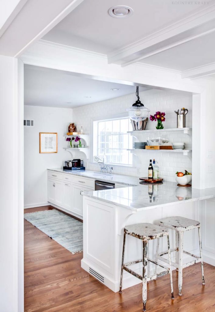 Decorator White Cabinets featuring dishwasher and a counter with two stools Upper Montclair, NJ