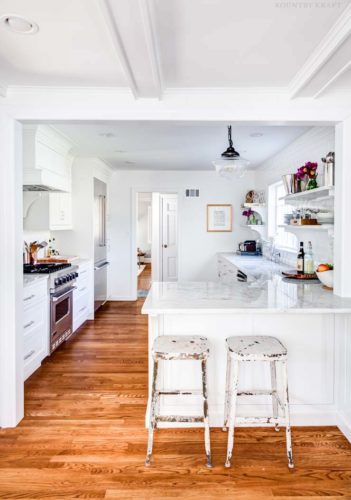 Counter, two stools, range, and refrigerator in a white kitchen Upper Montclair, NJ