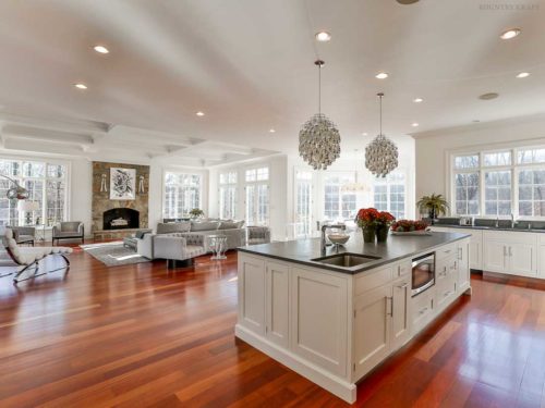 View of kitchen island, white shaker cabinets, and living room New Canaan, CT